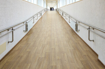 Obraz premium A long corridor equipped with handrails to facilitate the movement of people with disabilities