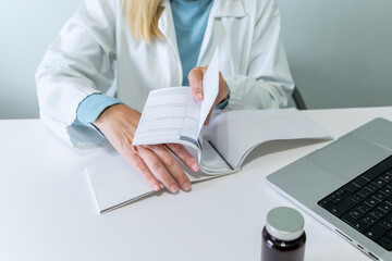 Female doctor writing prescriptions in medical office