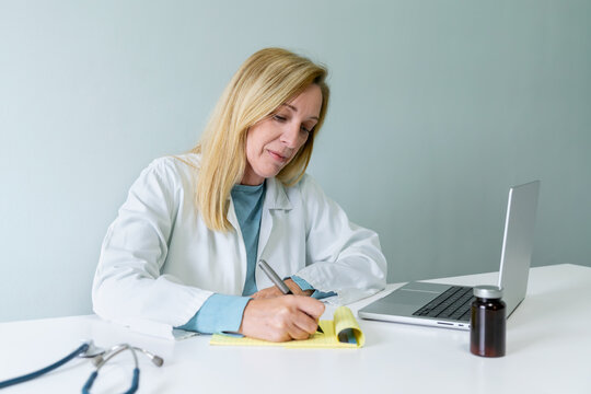 Female doctor writing prescriptions in medical office