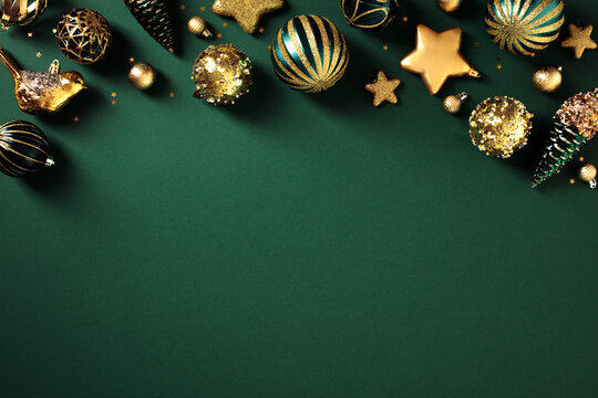 Elegant gold and emerald green Christmas ornaments creating a festive top border on dark green background.