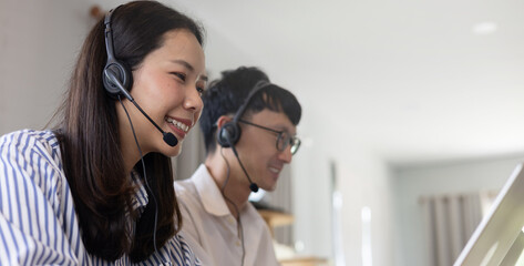 close up team of asian call center agent woman and man wear headset device and smiling working in operation room with service-mind at desktop table , telemarketing and help desk concept