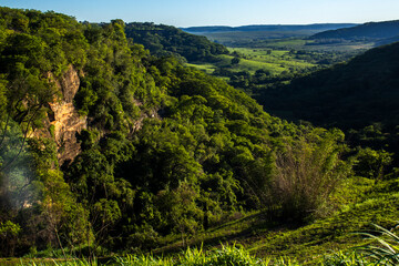 Stunning cliff formation in a lush green valley in Sao Paulo state. A landmark representing the region unique geology, farm pastures and the beauty of the Atlantic Forest biome