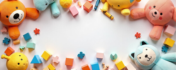 Colorful collection of plush toys and building blocks arranged on a white surface for creative playtime