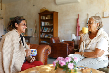 Diverse women friends enjoying coffee and conversation at home