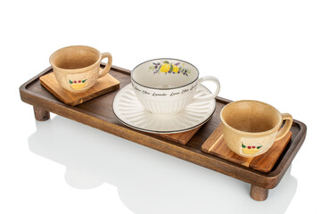 Wooden table with ceramic cups isolated on white background, close-up.
