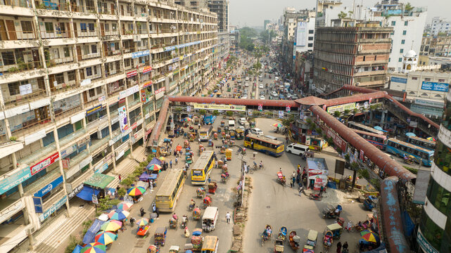 Aerial view of bustling streets teeming with rickshaws, buses, cars, and pedestrians beneath the elevated footbridge, Dhaka, Dhaka, Bangladesh.