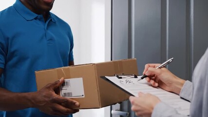 Delivery person handing over a package to a customer who is signing for the receipt on a clipboard video 4k