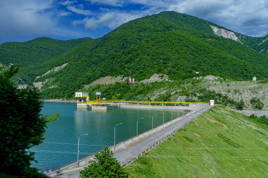 Mountain reservoir dam road leading to small hydro control buildings
