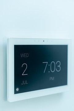 Modern wall clock displaying date and time in a home