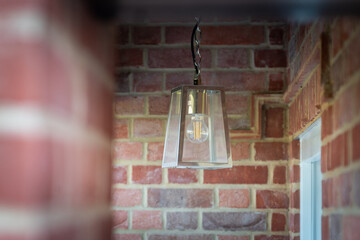 Modern light fixture against exposed brick wall