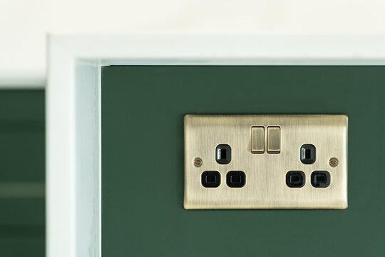Wall socket on green wall in modern London home