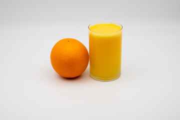 Fresh orange and a glass of orange juice on a white background, symbolizing health, vitamins, fresh produce, and healthy nutrition.