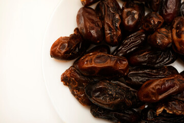Juicy dates on a plate. Dried fruits. Sweet dried fruits.