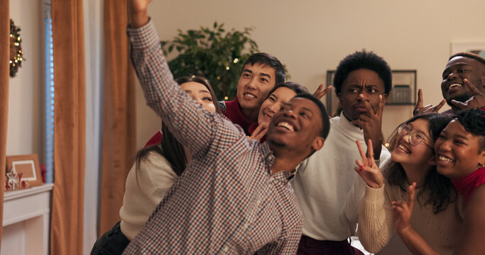 The end of the session is celebrated at a party where students dance. A multi-ethnic guy in a shirt takes a selfie with his friends (boys and girls) who are posing after he pulls a phone from his - Powered by Adobe