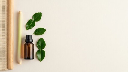 Natural essential oil bottle with fresh green leaves and bamboo sticks on a light background.
