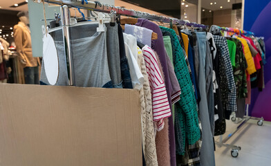 Clothes on hangers during a clothing swap event promoting sustainable fashion and reuse. Eco-friendly lifestyle, recycling, and circular economy concept encouraging people to exchange pre-loved