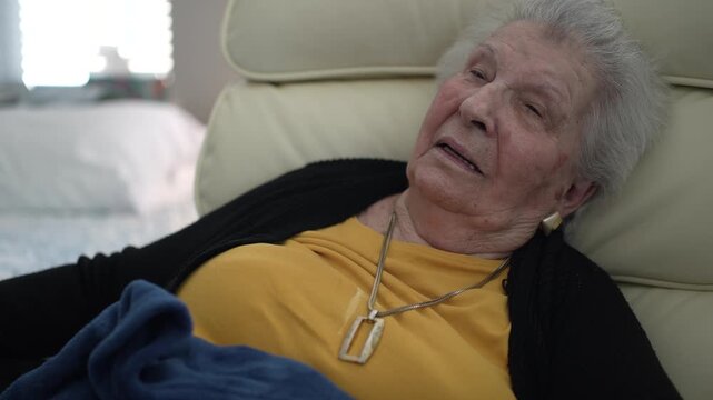 Elderly woman relaxes in her chair at a healthcare facility, capturing a quiet moment of reflection and care in her daily life.
