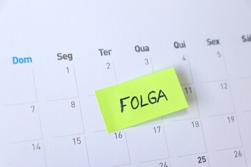Sticky Note with "Folga" on Calendar. Day off concept. Folga is day off in Portuguese. 