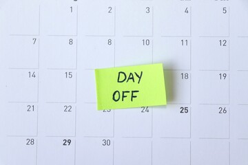 Day Off Marked on Calendar. Sticky Note Reminder. Workplace message in the office. Concept of absence from work and day off.