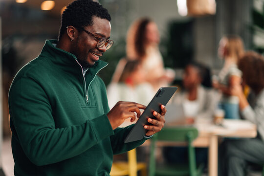 Happy african american man using tablet in office