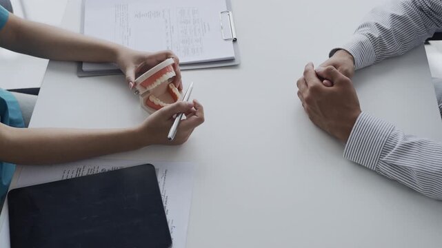 dentist provides oral health advice to a patient in a consultation room