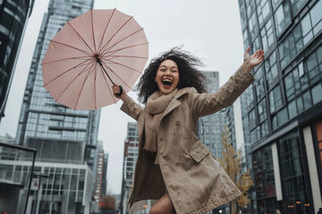 Cheerful young woman holding an umbrella, laughing and jumping with arms outstretched on a cloudy day in a modern urban environment, embracing carefree happiness in the rain