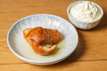 Baba au rhum avec chantilly sur une table en bois