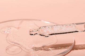 Gel textured facial serum with pipette on a pink background