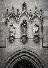 Snowflakes fall in front of the wall section decorated with figures at the entrance arch to the &ldquo;M&uuml;ntzer unserer lieben Frau&rdquo; (Church of Our Lady). Constance, Baden W&uuml;rttemberg, Germany.
