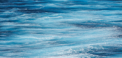 Sea surface aerial view. Background shot of clear sea water surface. Blue sea water in calm. Sea texture. Background blue waves of the ocean	