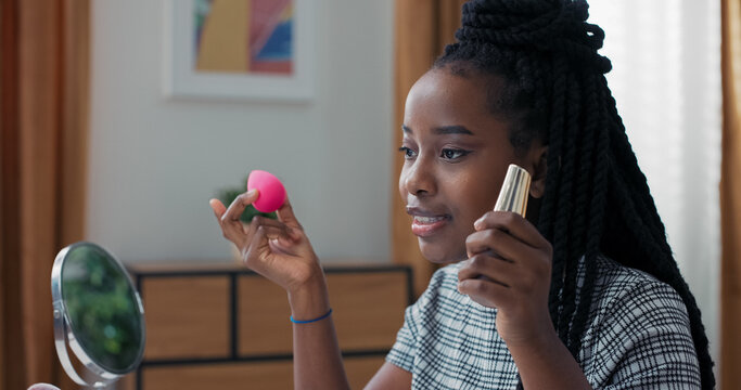 Beauty blogger hosts live session, demonstrating how to apply foundation with sponge. Close-up view shows woman giving clear instructions on smooth and even makeup application.