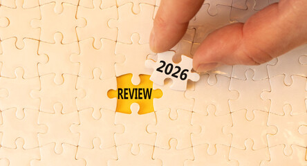 Review 2026 symbol. Concept words Review 2026 on beautiful white puzzles. Beautiful white puzzles background. Businessman's hand. Business and review 2026 concept. Copy space.