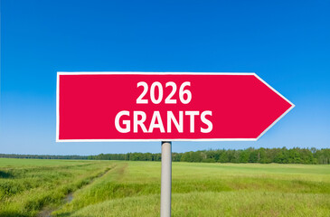 2026 Grants symbol. Concept words 2026 Grants on beautiful red road sign. Beautiful green grass field forest and blue sky background. Business and 2026 grants concept. Copy space.