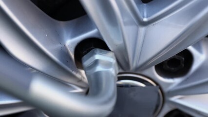 Process of tightening nuts during installation of wheel at service center. Lug wrench helps secure large round construction to suspension system of automobile for further repair tasks