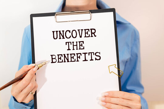 Uncover the Benefits - text written on notebook on wooden table with pen coffee and glasses