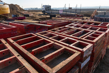 Stacked red steel formwork panels for concrete lie ready