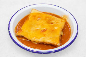Francesinha – plat typique de Porto au Portugal servi sur un plat traditionnel sur une table en bois