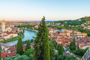 Panoramic aerial view of Verona old town with Adige River, terracotta rooftops, cypress trees,...
