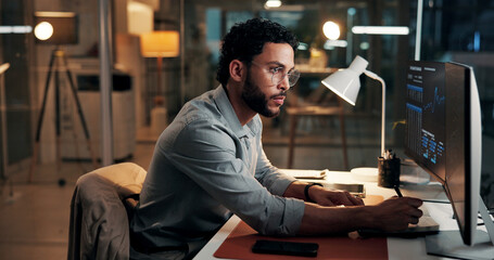 Computer, trading and business man writing notes for stock market, finance data and night. Trader, notebook and serious person with desktop for investment chart, risk management or overtime in office