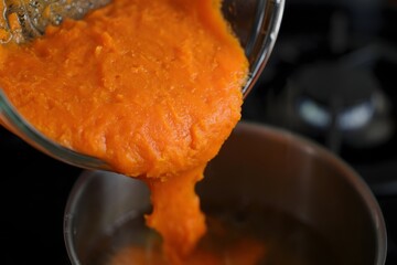 Pureed Pumpkin Filling Pouring Into Bowl - Autumn Food Preparation