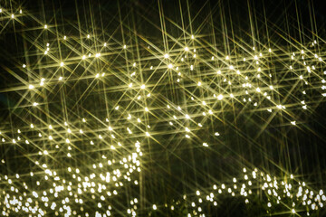 Fototapeta premium Bright, sparkling lights create a mesmerizing bokeh effect against a dark background, enhancing the atmosphere with a sense of magic and wonder, perfect for festive celebrations