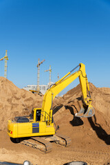 A large yellow excavator works on a construction site