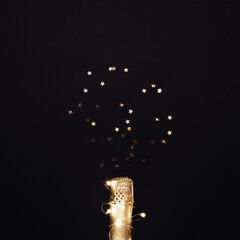 Champagne bottle with garlands on dark background
