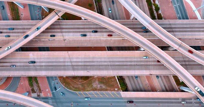 Descend over the highways and trestles with multiple cars moving by. Traffic in the modern city.