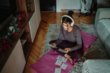 Obraz premium Woman planning home workout using exercise cards