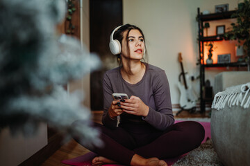 Woman relaxing at home, enjoying music with headphones