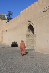 Old man Walking Through Traditional Stone Archway Alley