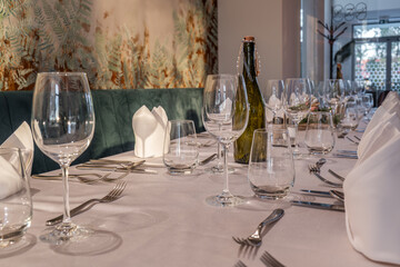 Close-up of formal table setting with wine glasses and bottle
