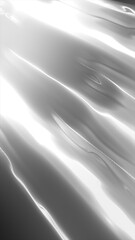 A dynamic flowing texture, with smooth and reflective surfaces, showcasing streaks of light and shadow play in a soft grayscale tone