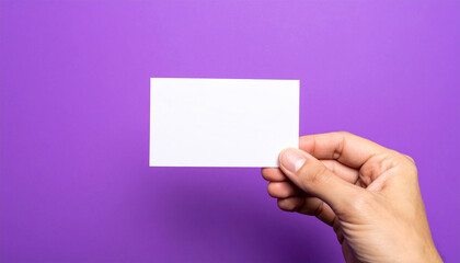 Obraz premium Hand holding blank card, vibrant purple background, minimalistic and clean presentation. Mock-up.